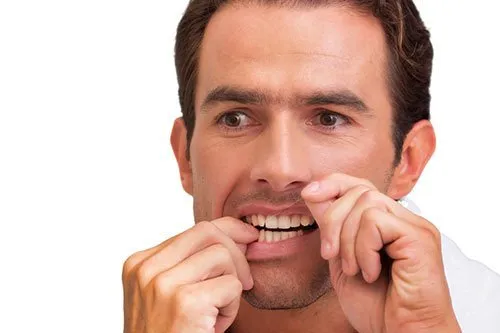 man flossing his teeth
